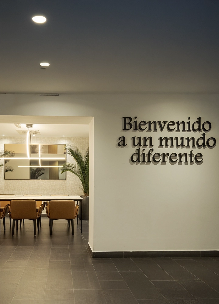 Entrada moderna con una frase de bienvenida en la pared que dice: 