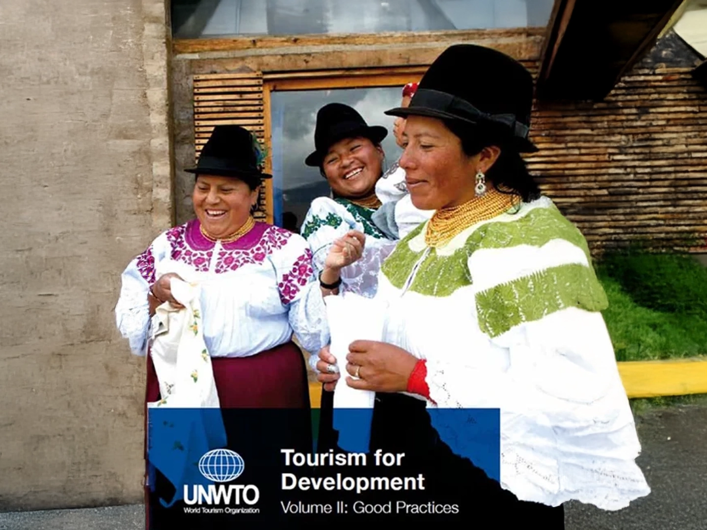 Tres mujeres con ropa tradicional sonríen mientras participan en una actividad cultural al aire libre, mostrando alegría y diversidad comunitaria.