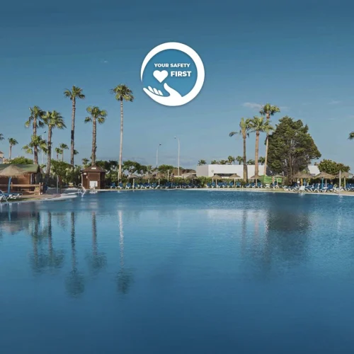 Hotel con piscina al aire libre con agua clara. Con un logo de una mano en el centro que tiene el texto 