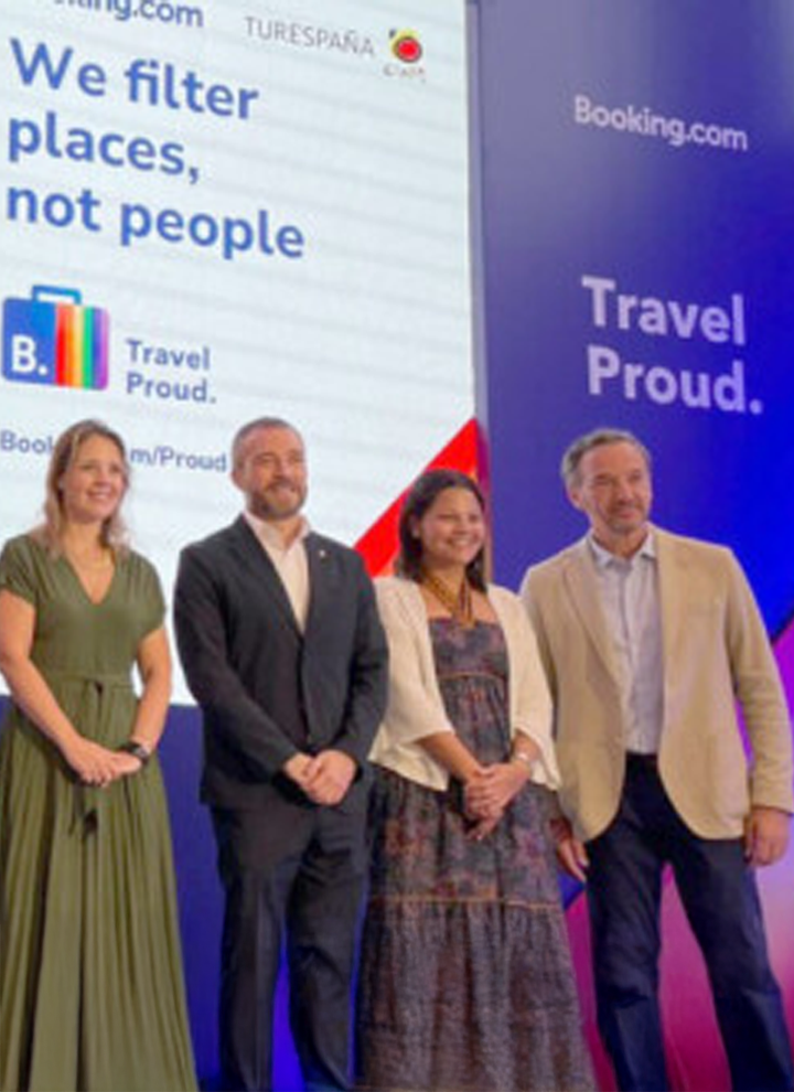 Cuatro personas posando frente a un panel con el texto We filter places, not people y logotipos de Booking.com y Turespaña.