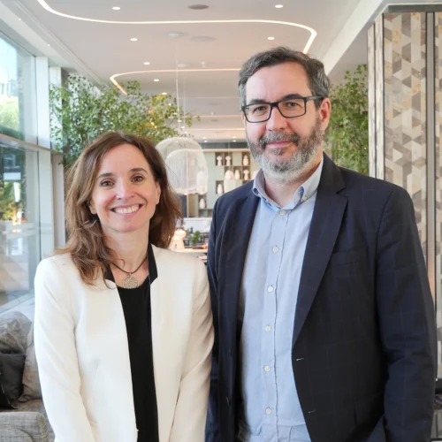 Teresa Zamora Garcia y Jorge Barrero. Posan sonrientes ante la cámara, en el hall de ILUNION Atrium