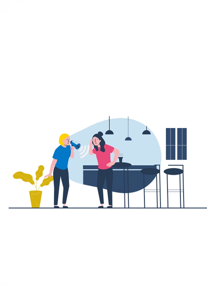 Una ilustración plana y colorida muestra a dos mujeres en un espacio interior estilizado. A la izquierda, una mujer con cabello rubio corto, piel clara, una camiseta azul, pantalones azul oscuro y zapatos a rayas está de pie sosteniendo un megáfono azul y blanco cerca de su boca, con ondas de sonido onduladas saliendo de él. Su mano derecha descansa sobre una planta de hojas amarillas en una maceta amarilla. A la derecha, otra mujer con cabello oscuro recogido en un moño, piel clara, una camiseta rosa, pantalones azul oscuro y zapatos a rayas se tapa la oreja derecha con la mano izquierda y tiene la mano derecha en la cadera, con una expresión de sorpresa o molestia. Detrás de ellas, un fondo azul claro sugiere una habitación con una barra azul oscuro, dos taburetes negros altos, lámparas colgantes negras y una ventana con persianas.
