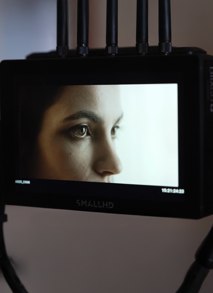 Close-up of a monitor with four antennas on top. The screen displays a blurred image on the left side and a white area on the right. A timestamp 