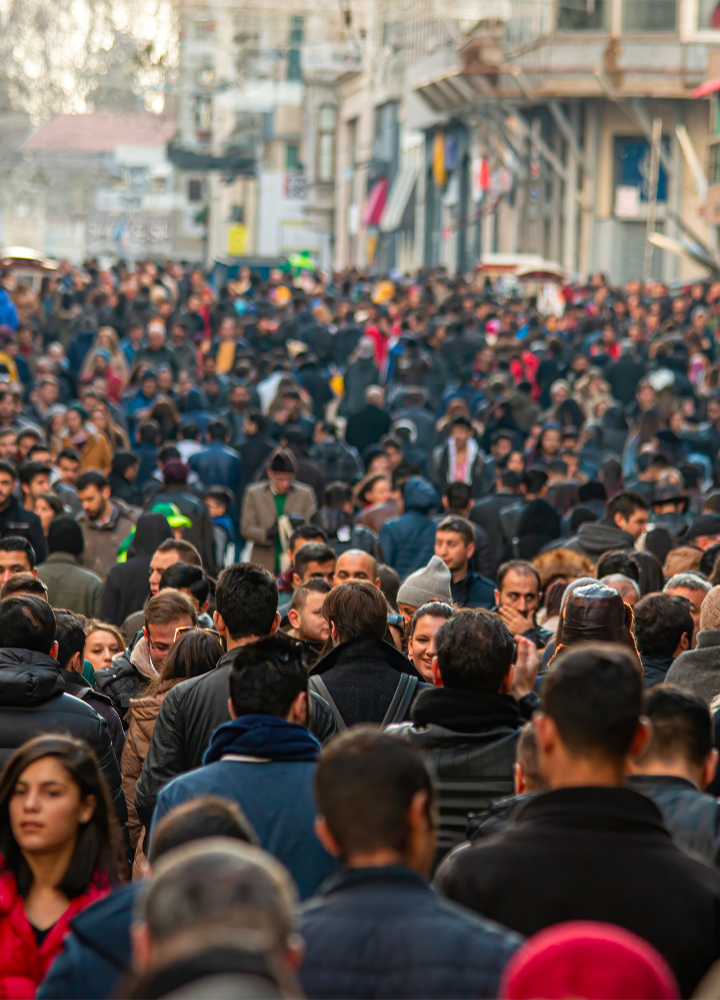 Masa de personas caminando por una calle urbana