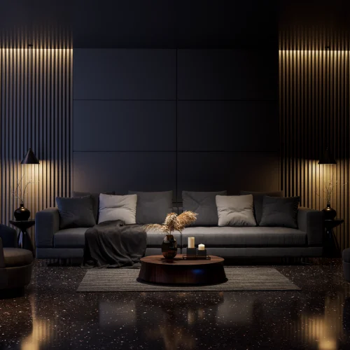 A modern living room with a dark and sophisticated style. It features a large gray sofa with cushions, a round table adorned with candles and dried plants, a matching rug, warm vertical lighting on a dark wall, and a polished floor that adds an elegant touch.
