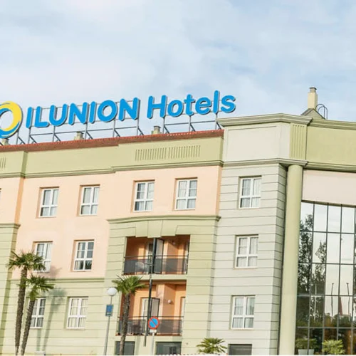 Fachada verde de un hotel de ILUNION Hotels.