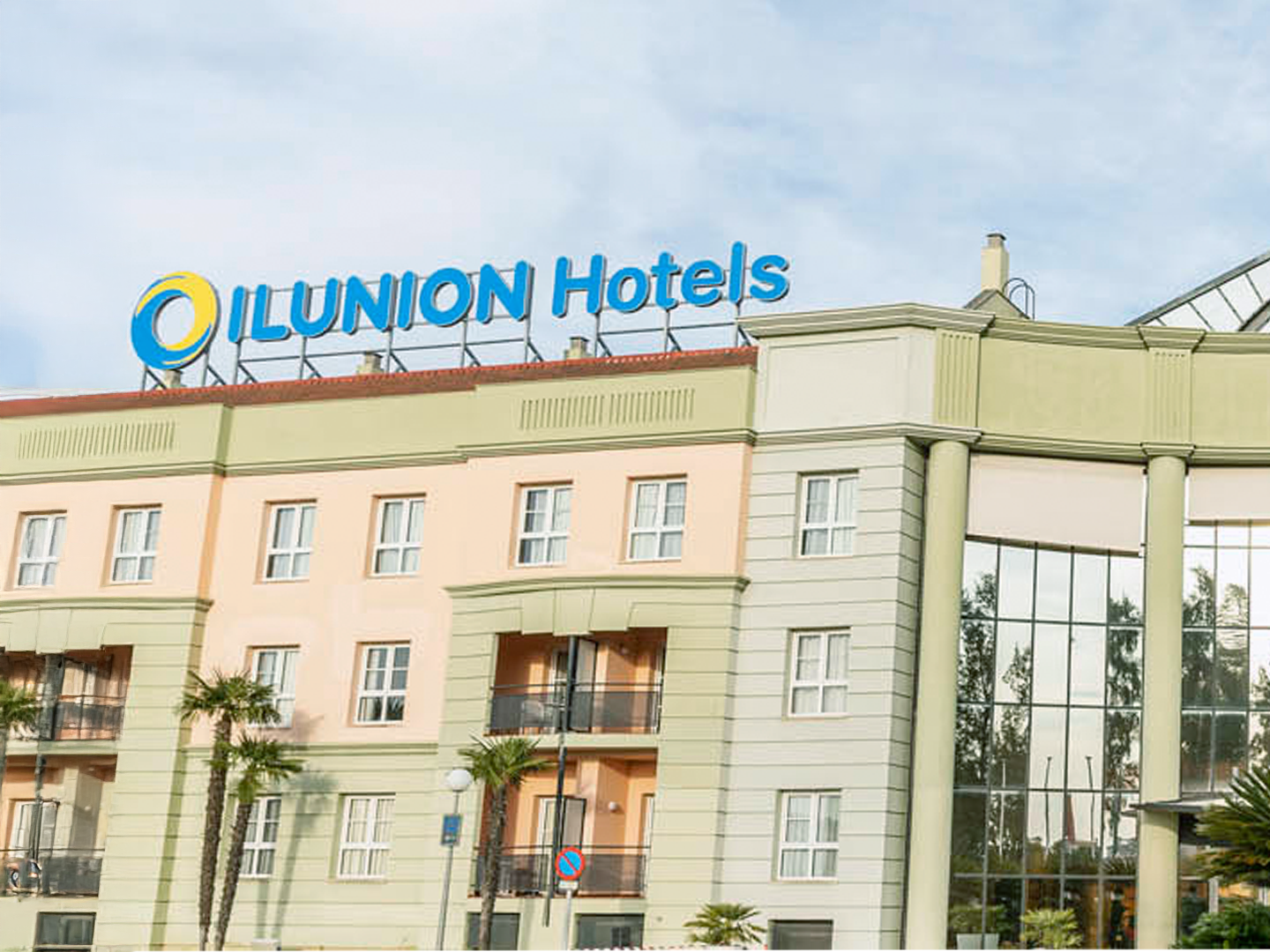 Fachada verde de un hotel de ILUNION Hotels.
