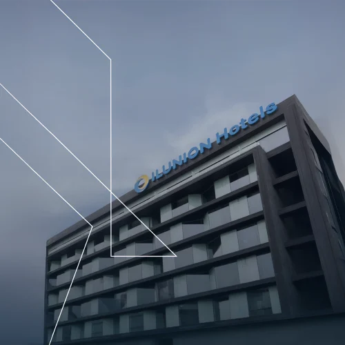 Facade of the ILUNION Atrium Hotel viewed with a circular hologram and a line graph decorating the side.