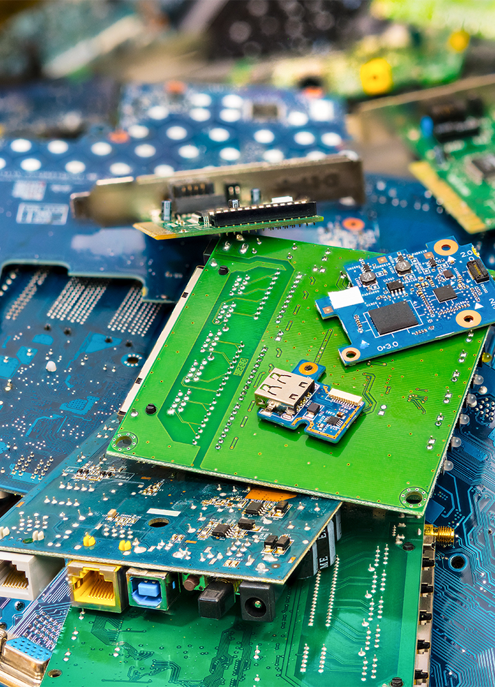 Pila desordenada de placas electrónicas con chips, puertos USB y componentes visibles