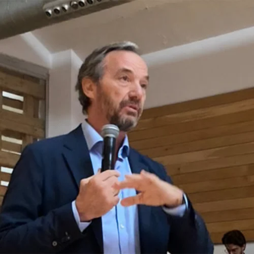 Jose Ángel Preciados in an indoor space speaking with a microphone in hand.