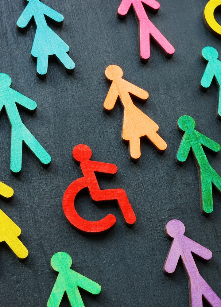 Accessibility icons made of painted wood in different colors on a black background.