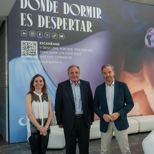 José Guillermo Díaz, Tereza Zamora, and José Ángel Preciados posing at ILUNION Atrium Hotel. In the background, the phrase “Where sleeping means awakening” is visible.