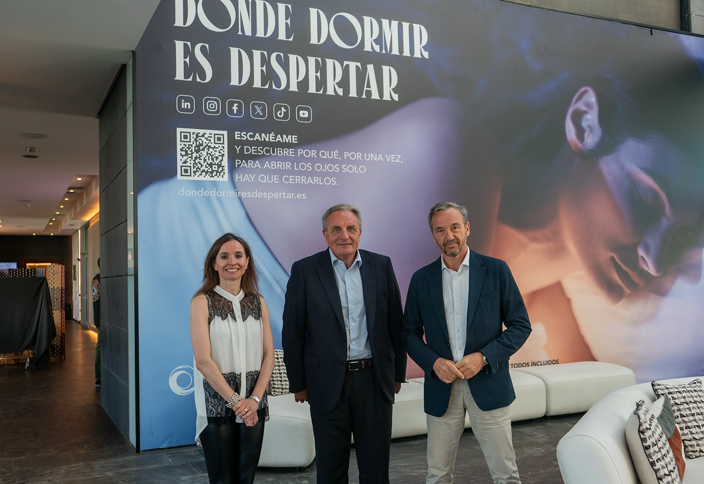 José Guillermo Díaz, Tereza Zamora, and José Ángel Preciados posing at ILUNION Atrium Hotel. In the background, the phrase “Where sleeping means awakening” is visible.