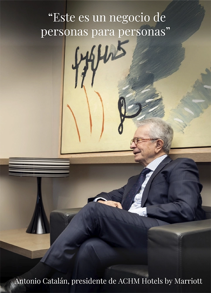Hombre mayor con traje y camisa a rayas, sentado en sillón negro frente a pintura abstracta. Texto: “Este es un negocio de personas para personas.”