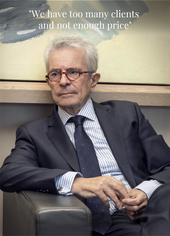 Antonio Catalán seated in front of abstract artwork. Text on image reads: 'We have too many clients and not enough price'