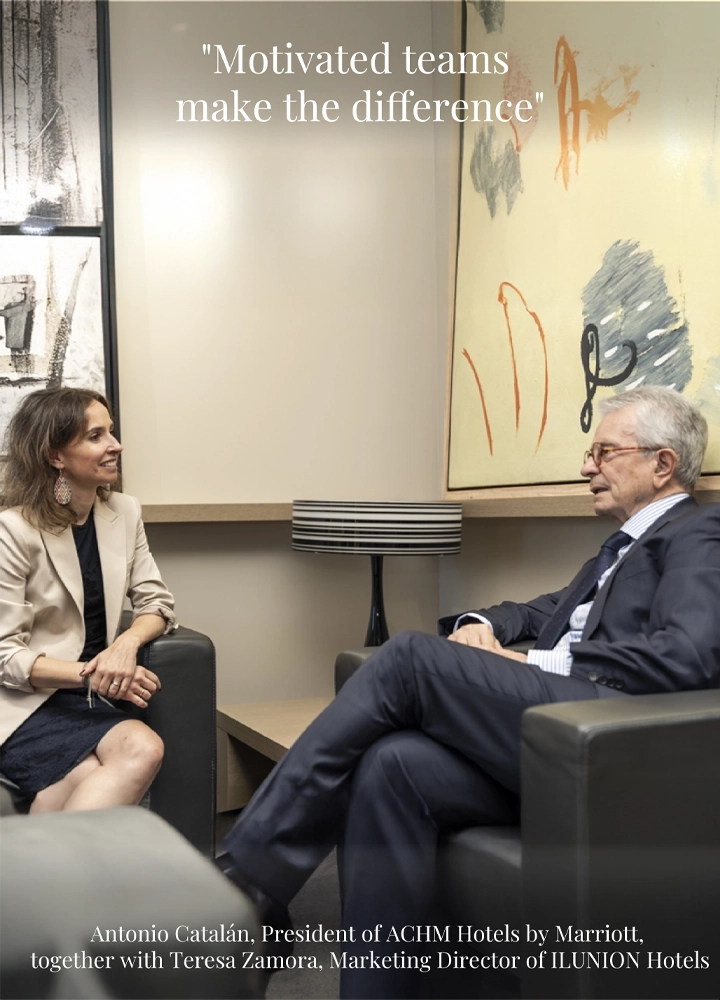 Antonio Catalán and Teresa Zamora seated in a professional setting with abstract art and a lamp. Text reads: 'Motivated teams make the difference'.