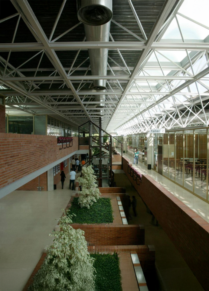 Bright and modern interior of UNAV with metal structure, decorative plants, and people interacting in an educational environment.