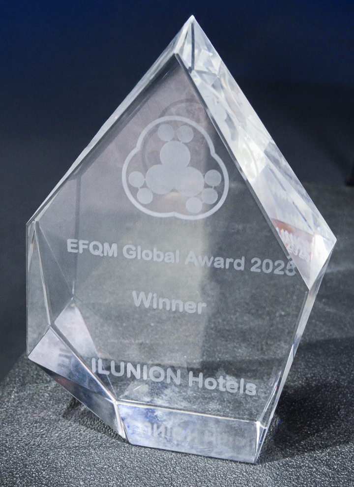 Trofeo de cristal con forma geométrica grabado con el texto EFQM Global Award 2023 Winner ILUNION Hotels.