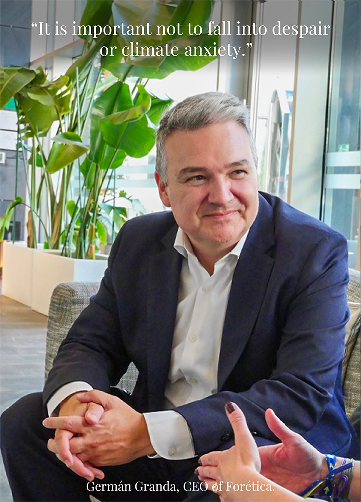 A man seated on a sofa in a modern indoor setting with large green plants in the background, wearing a dark suit and white shirt. Upper text reads: ‘It is important not to fall into despair or climate anxiety.’ Lower text reads: ‘Germán Granda, CEO of Forética.’