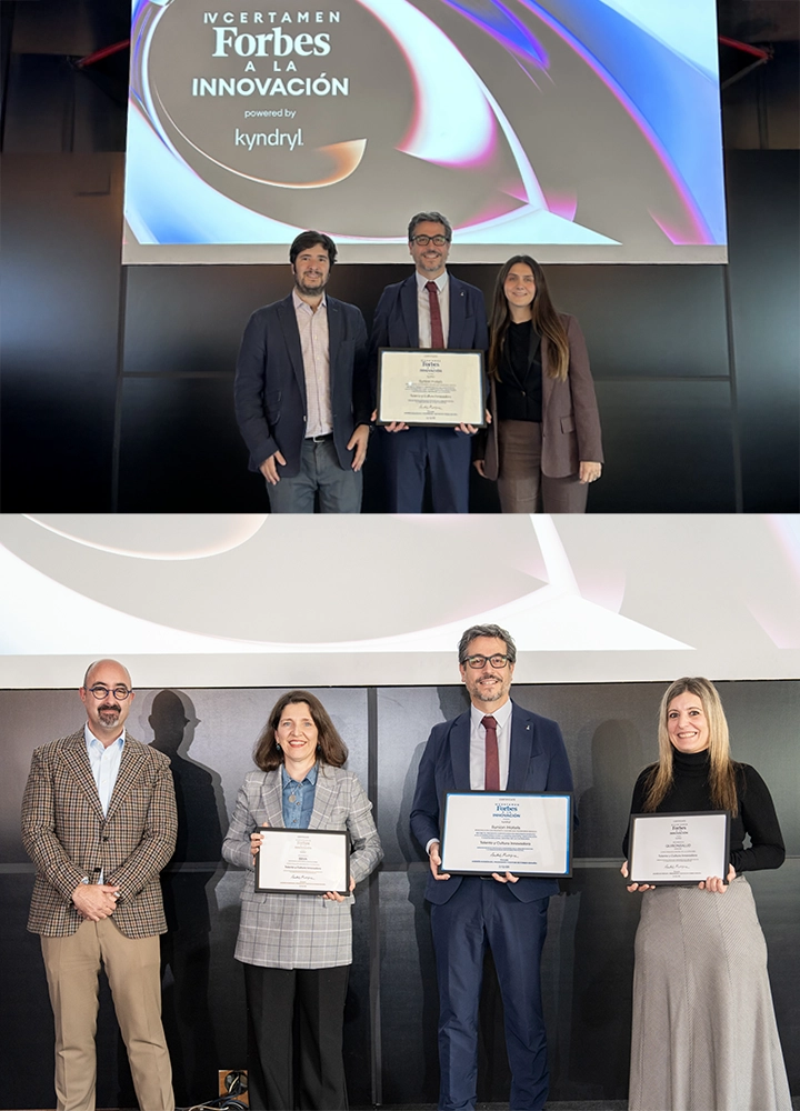 Foto superior: Dos hombres y una mujer posan en el escenario del IV Certamen Forbes a la Innovación, con el logo de Kyndryl al fondo. El centro sostiene un diploma enmarcado, destacando el reconocimiento recibido. Foto inferior: Dos hombres y dos mujeres posan frente al mismo fondo institucional. Tres de ellas muestran diplomas, incluida la persona que aparece también en la imagen superior, reforzando su protagonismo en el evento.