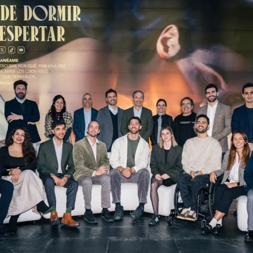 Grupo de personas posando en un evento corporativo frente a un gran cartel que dice 