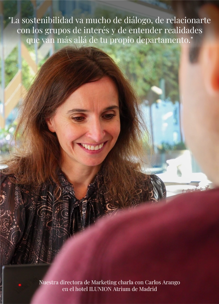 Una mujer conversa con un hombre en una mesa de un espacio luminoso. En la parte superior se lee: “La sostenibilidad va mucho de diálogo, de relacionarte con los grupos de interés y de entender realidades que van más allá de tu propio departamento”. En la parte inferior se indica que la directora de Marketing charla con Carlos Arango en el hotel ILUNION Atrium de Madrid