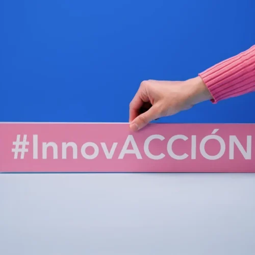 Mano sujetando un cartel rosa con el hashtag blanco 