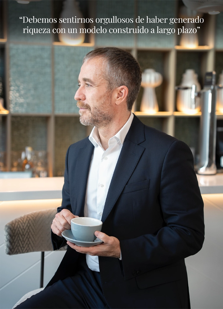 Miguel Sanz, director general de Turespaña, sentado de perfil sosteniendo una taza de café en un ambiente moderno. En la parte superior, la cita: 