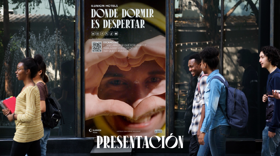 Varias personas caminando frente a un escaparate acristalado que muestra un cartel de ILUNION Hotels con el título Donde dormir es despertar. Al lado derecho, la palabra Presentación aparece en letras blancas sobre el vidrio.