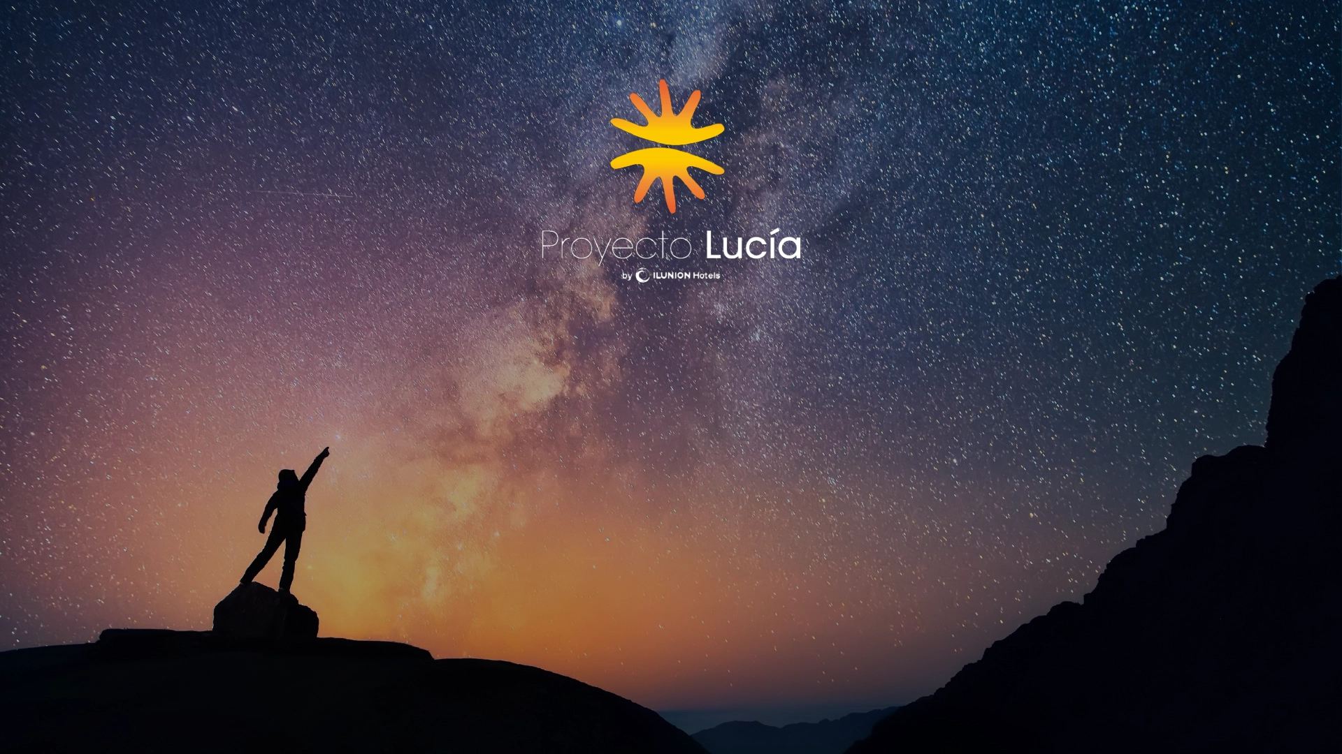 Cielo estrellado con la Vía Láctea sobre un horizonte anaranjado; una figura en lo alto de una roca apunta al cielo. En el centro superior aparece el logotipo amarillo y el texto Proyecto Lucía de ILUNION Hotels.