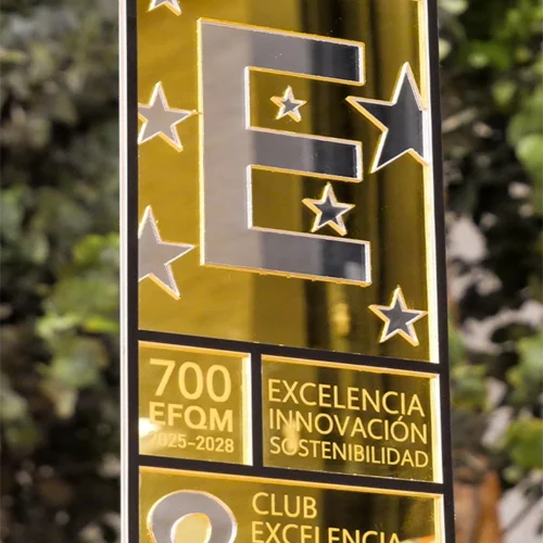 Una placa dorada con la letra “E” grande rodeada de estrellas, que reconoce la excelencia, innovación y sostenibilidad de una entidad para el período 2025-2028, otorgada por el Club Excelencia en Gestión.