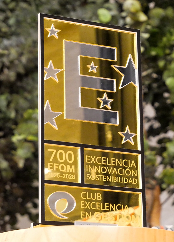 Una placa dorada con la letra “E” grande rodeada de estrellas, que reconoce la excelencia, innovación y sostenibilidad de una entidad para el período 2025-2028, otorgada por el Club Excelencia en Gestión.
