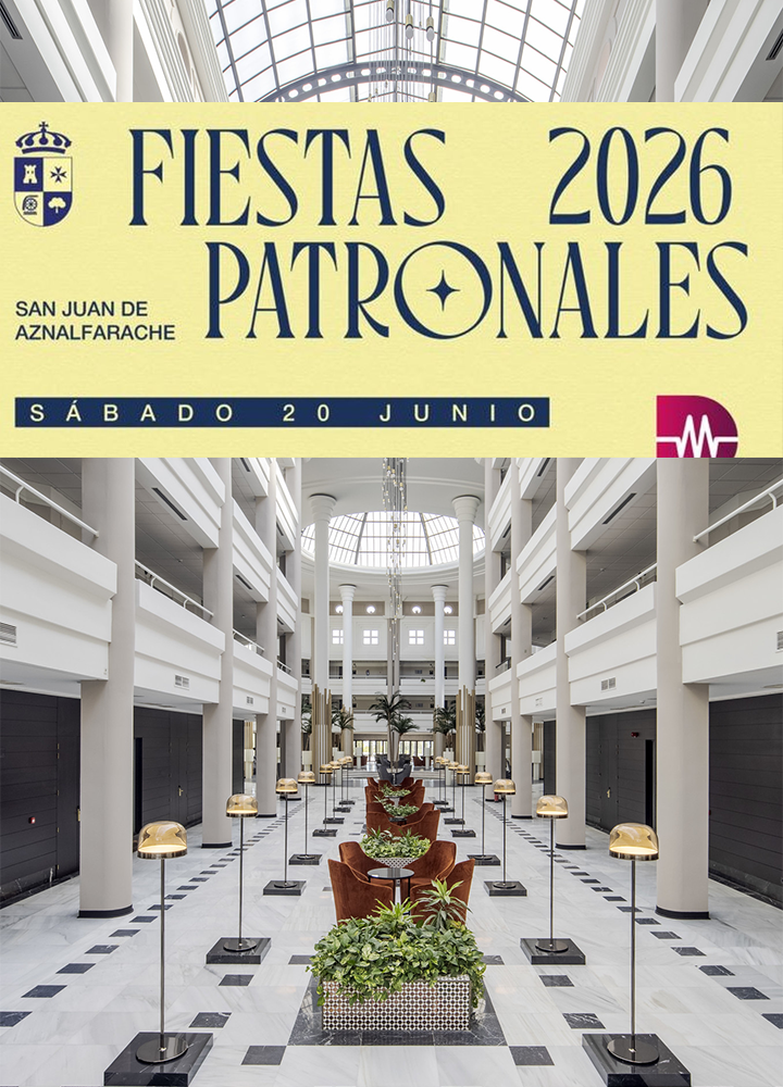 Cartel con una franja superior en tono amarillo donde aparece el texto “FIESTAS PATRONALES 2026” en letras grandes, acompañado del escudo a la izquierda y la mención “SAN JUAN DE AZNALFARACHE”, y debajo “SÁBADO 20 JUNIO”. En la parte inferior se aprecia el interior de un edificio amplio y simétrico con columnas blancas altas, suelo de mármol con patrón geométrico y una claraboya acristalada en el techo que deja pasar luz natural; a lo largo del pasillo central se alinean lámparas doradas sobre soportes y zonas de descanso con sillones marrones y plantas verdes, creando una composición ordenada y luminosa.