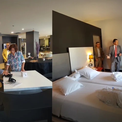 Dos escenas de una visita a un hotel accesible. A la izquierda, varias personas observan una demostración junto a una mesa con dispositivos y material informativo en una zona común del establecimiento. A la derecha, varias personas recorren una habitación con dos camas individuales y equipamiento adaptado, mientras una persona realiza explicaciones sobre las características del espacio. El entorno presenta una decoración contemporánea con iluminación cálida y mobiliario funcional.