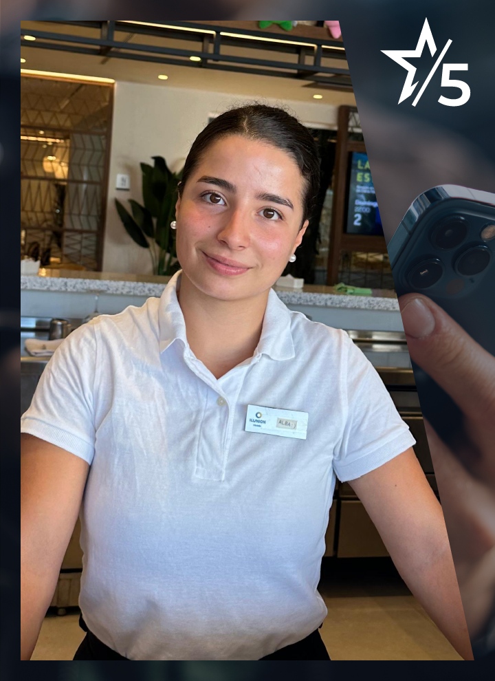 Persona con uniforme de trabajo posa frente a una barra de restauración, con una placa identificativa visible y el logotipo del 15.º aniversario en la esquina superior derecha.